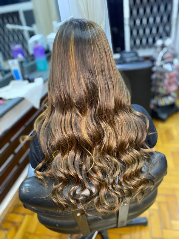 Cabelo longo castanho com mechas iluminadas e ondas suaves