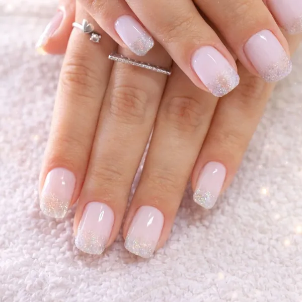Detalhe de unhas com degradê de glitter nas pontas