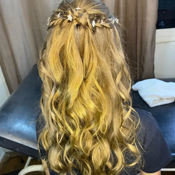 Cabelo loiro com ondas e semipreso decorado com presilhas de flores